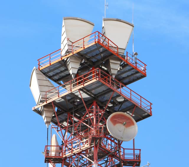 A tower topped with antennas and dishes that relay mobile signals across the island.