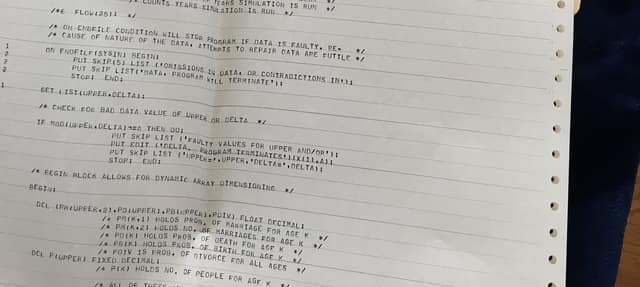 A printed 1973 program listing on striped paper, with comments explaining parts of the code.